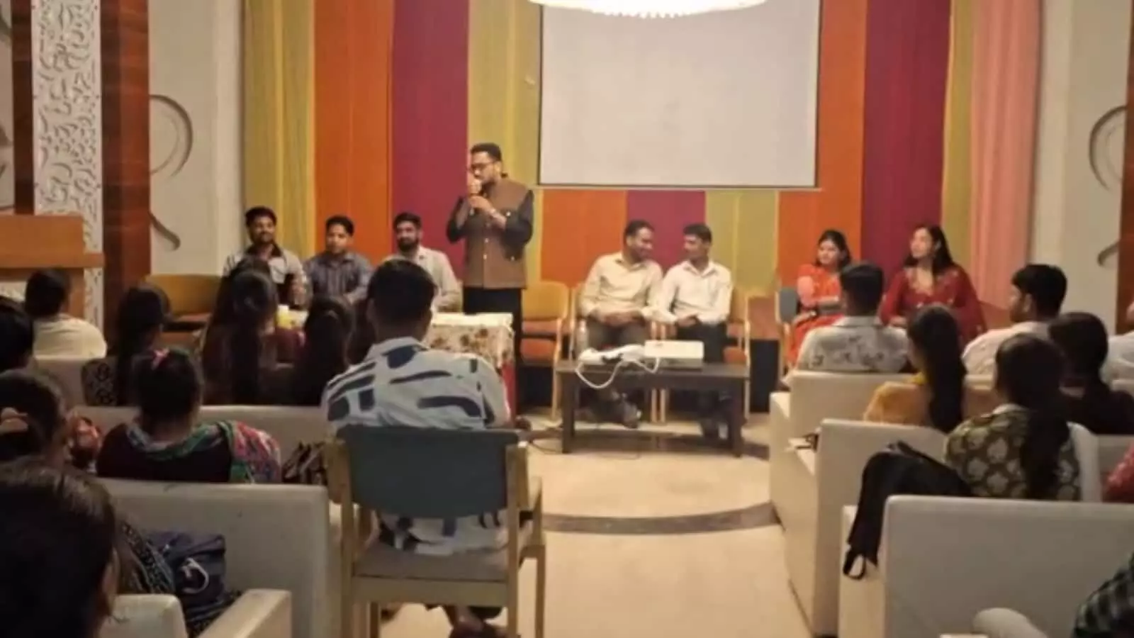 होटल के सभागार में मंच पर बैठे पदाधिकारियों के सामने उपस्थित नवनियुक्त सामुदायिक स्वास्थ्य अधिकारी।