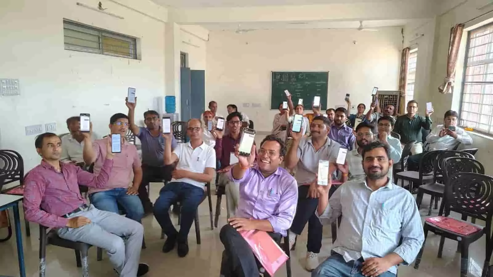 प्रशिक्षण कक्ष में स्मार्टफोन लहराते प्रगणक बेगूं में डिजिटल जनगणना 2027 का अभ्यास करते हुए।