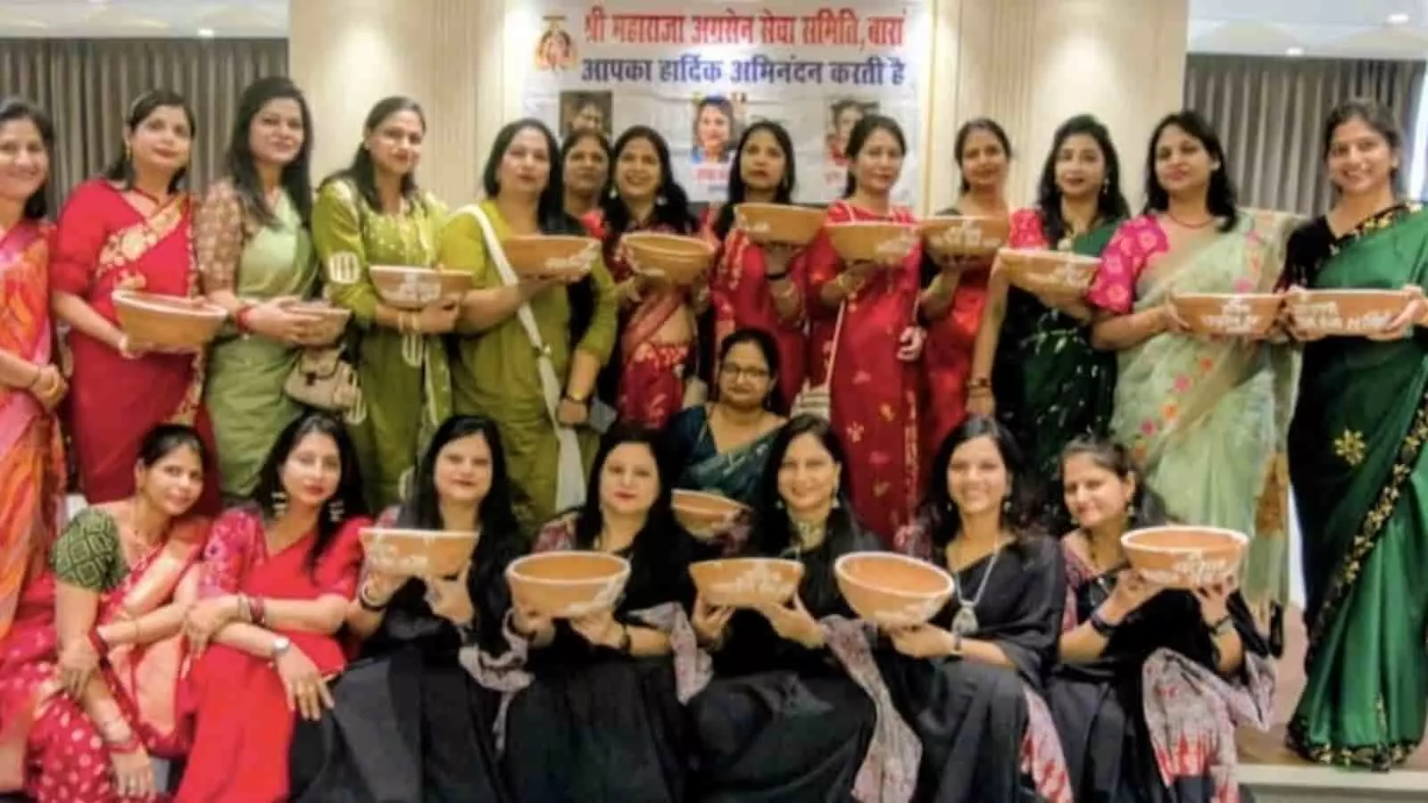 समिति की महिला सदस्याएं हाथों में मिट्टी के परिंडे लेकर सामूहिक चित्र के लिए खड़ी हैं।