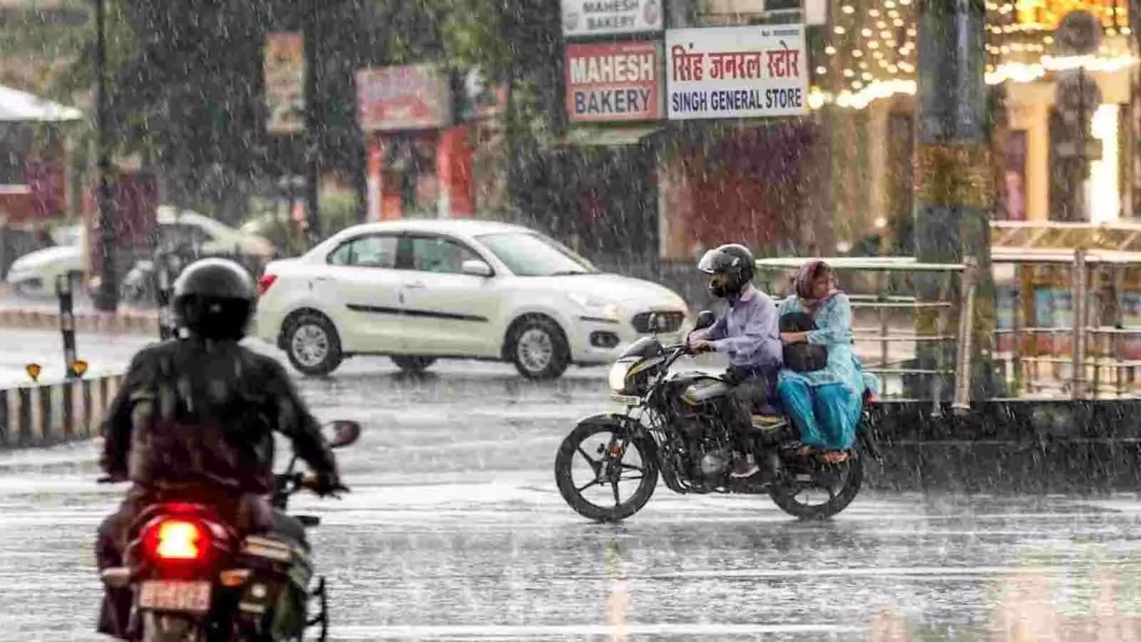 दिल्ली की सड़क पर बारिश के दौरान मोटरसाइकिल चलाते लोग और गीली सड़क का दृश्य। दिल्ली की सड़क पर बारिश के दौरान मोटरसाइकिल चलाते लोग और गीली सड़क का दृश्य।