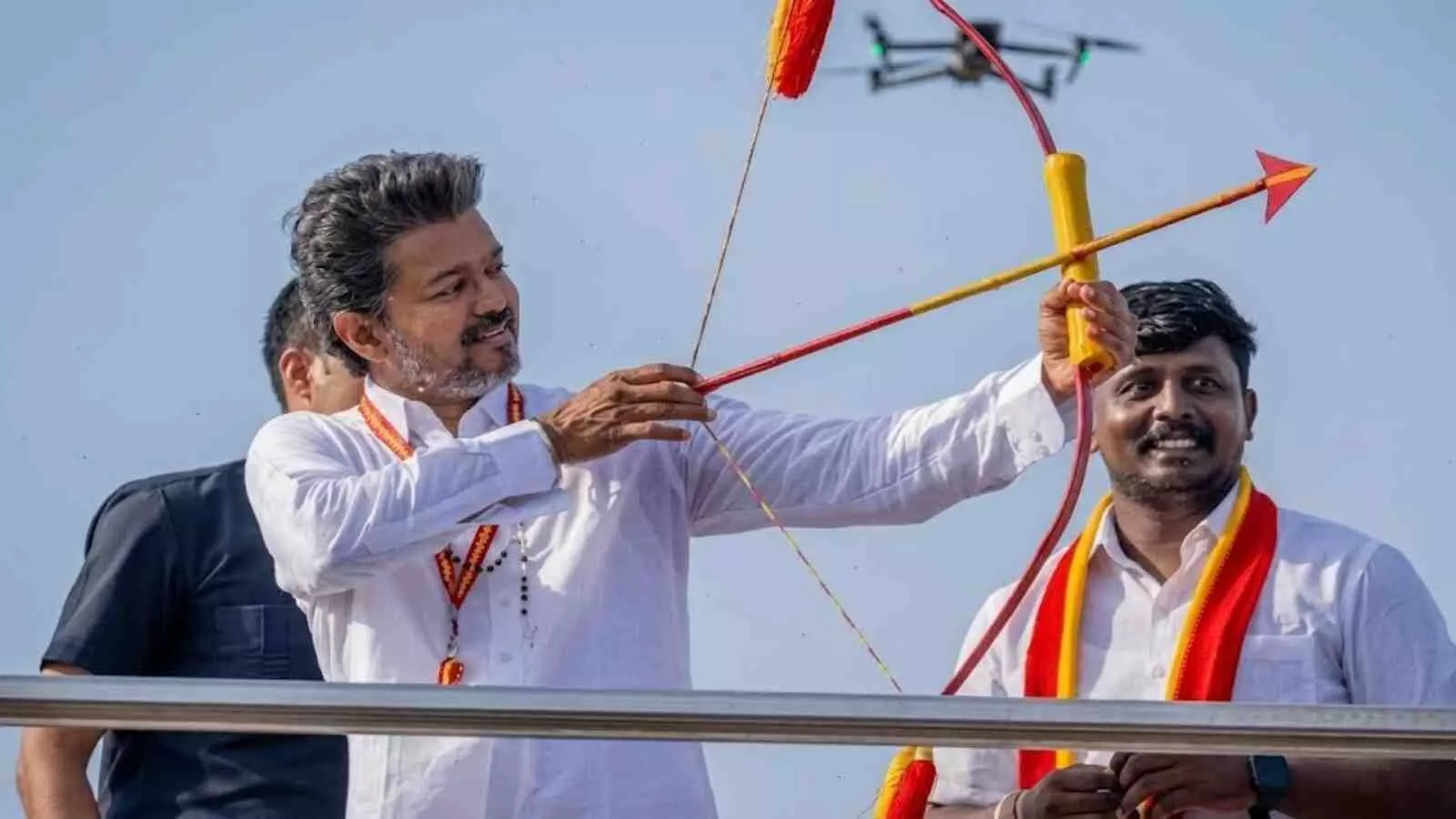 थलपति विजय धनुष और बाण लेकर जनता का अभिवादन कर रहे हैं।
