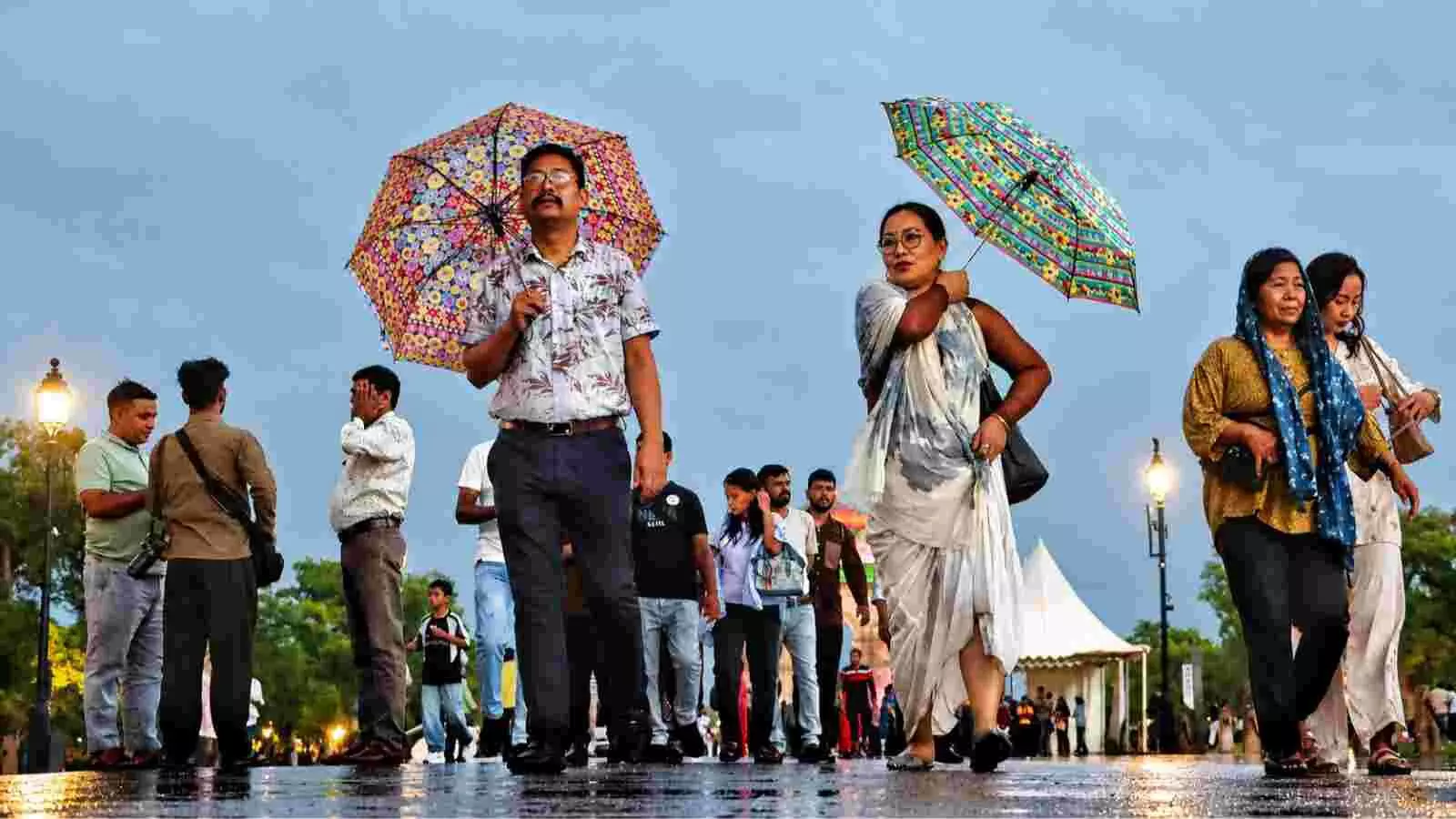 दिल्ली में बारिश के दौरान इंडिया गेट पर छाता लेकर पैदल चलते लोग और सुहावना मौसम। दिल्ली में बारिश के दौरान इंडिया गेट पर छाता लेकर पैदल चलते लोग और सुहावना मौसम।