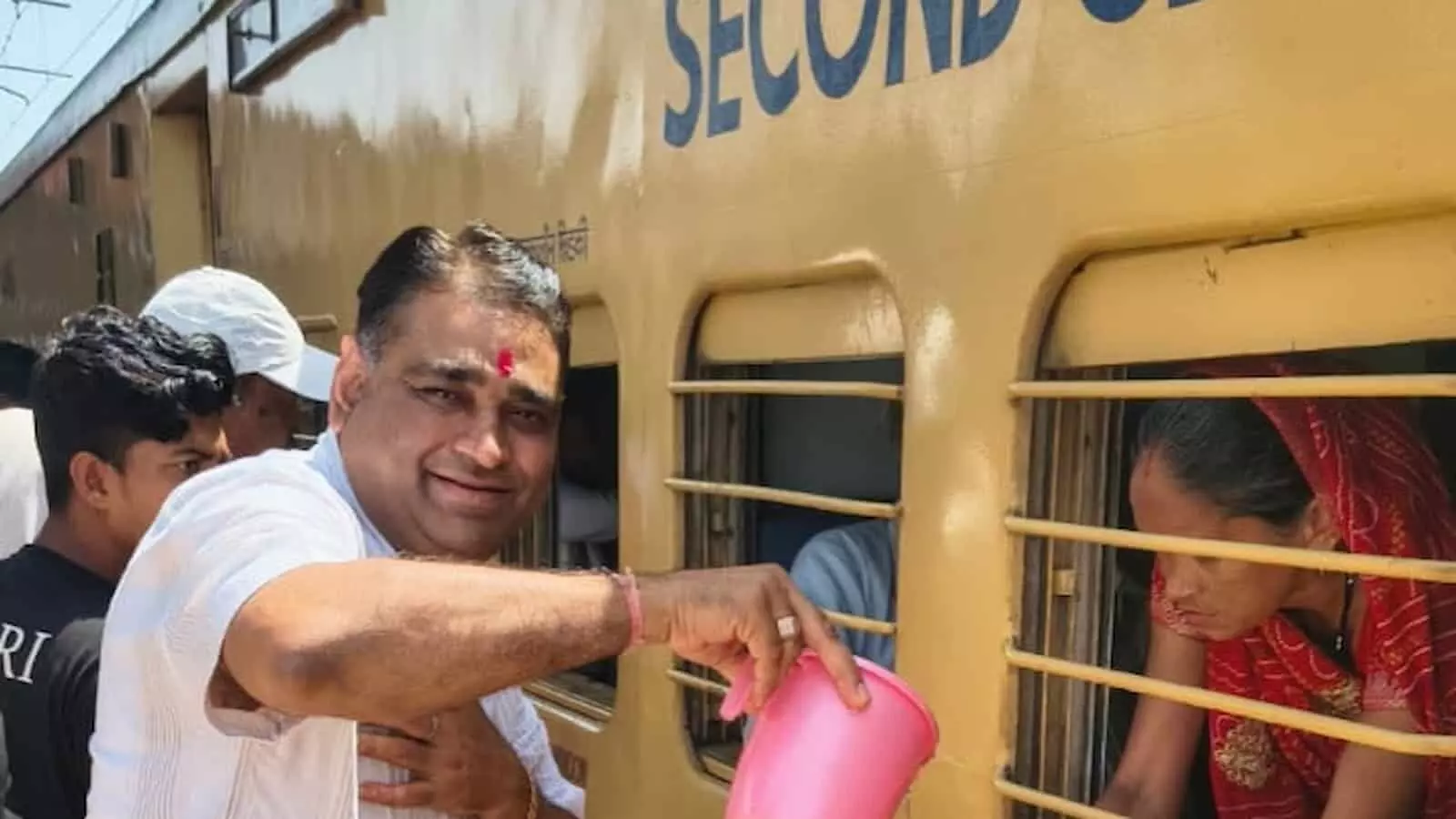 गंगापुर सिटी रेलवे स्टेशन पर कार्यकर्ता ट्रेन की खिड़की से यात्री को शीतल जल उपलब्ध करा रहे हैं। गंगापुर सिटी रेलवे स्टेशन पर कार्यकर्ता ट्रेन की खिड़की से यात्री को शीतल जल उपलब्ध करा रहे हैं।