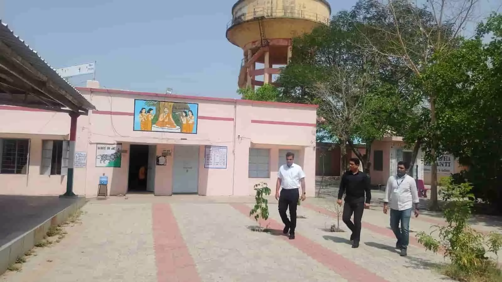 जयपुर के परीक्षा केंद्र परिसर में निरीक्षण के लिए चलते हुए प्रशासनिक अधिकारी और सुरक्षा कर्मी।