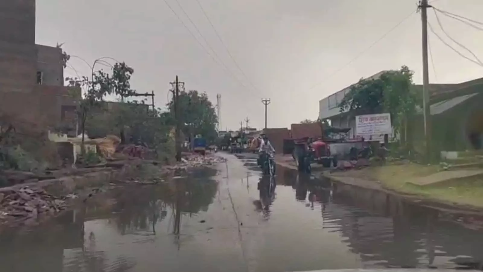 खानखेड़ा गांव में जलभराव से क्षतिग्रस्त मुख्य सड़क पर आवाजाही करते वाहन और राहगीर। खानखेड़ा गांव में जलभराव से क्षतिग्रस्त मुख्य सड़क पर आवाजाही करते वाहन और राहगीर।