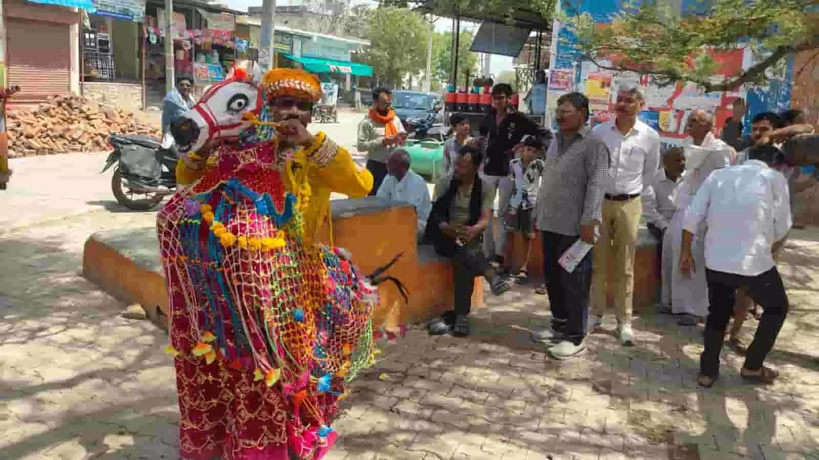 राजस्थान के एक गांव में पारंपरिक वेशभूषा में लोक कलाकार ग्राम रथ अभियान के दौरान प्रदर्शन कर रहा है। राजस्थान के एक गांव में पारंपरिक वेशभूषा में लोक कलाकार ग्राम रथ अभियान के दौरान प्रदर्शन कर रहा है।