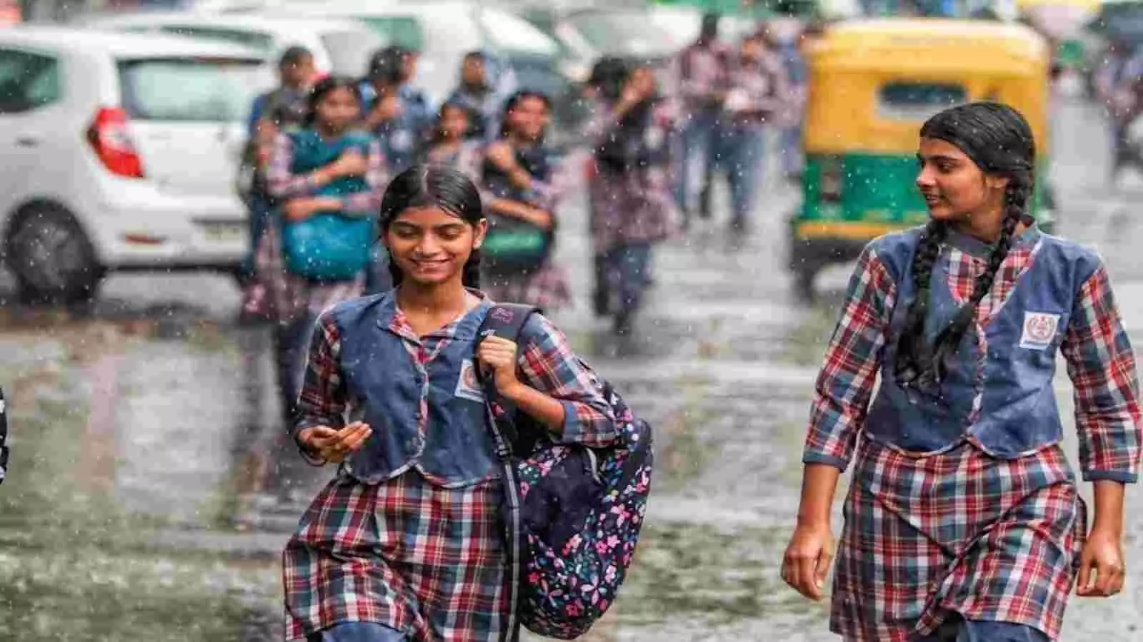 बारिश के बीच स्कूल यूनिफॉर्म में पैदल चलती छात्राएं और सड़क पर गुजरता ऑटो रिक्शा। बारिश के बीच स्कूल यूनिफॉर्म में पैदल चलती छात्राएं और सड़क पर गुजरता ऑटो रिक्शा।
