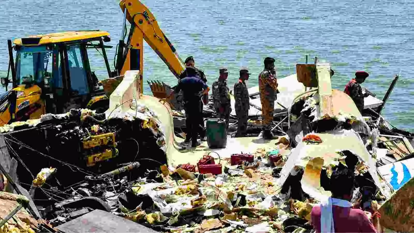 पानी के किनारे जेसीबी मशीन और बचाव दल के साथ क्षतिग्रस्त क्रूज का मलबा जबलपुर में। पानी के किनारे जेसीबी मशीन और बचाव दल के साथ क्षतिग्रस्त क्रूज का मलबा जबलपुर में।