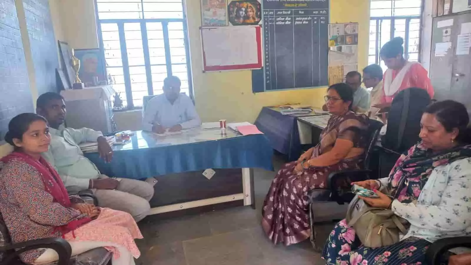 स्कूल के कार्यालय में मेज के चारों ओर बैठकर लाडो योजना के दस्तावेजों की समीक्षा करते शिक्षा और स्वास्थ्य विभाग के अधिकारी। स्कूल के कार्यालय में मेज के चारों ओर बैठकर लाडो योजना के दस्तावेजों की समीक्षा करते शिक्षा और स्वास्थ्य विभाग के अधिकारी।