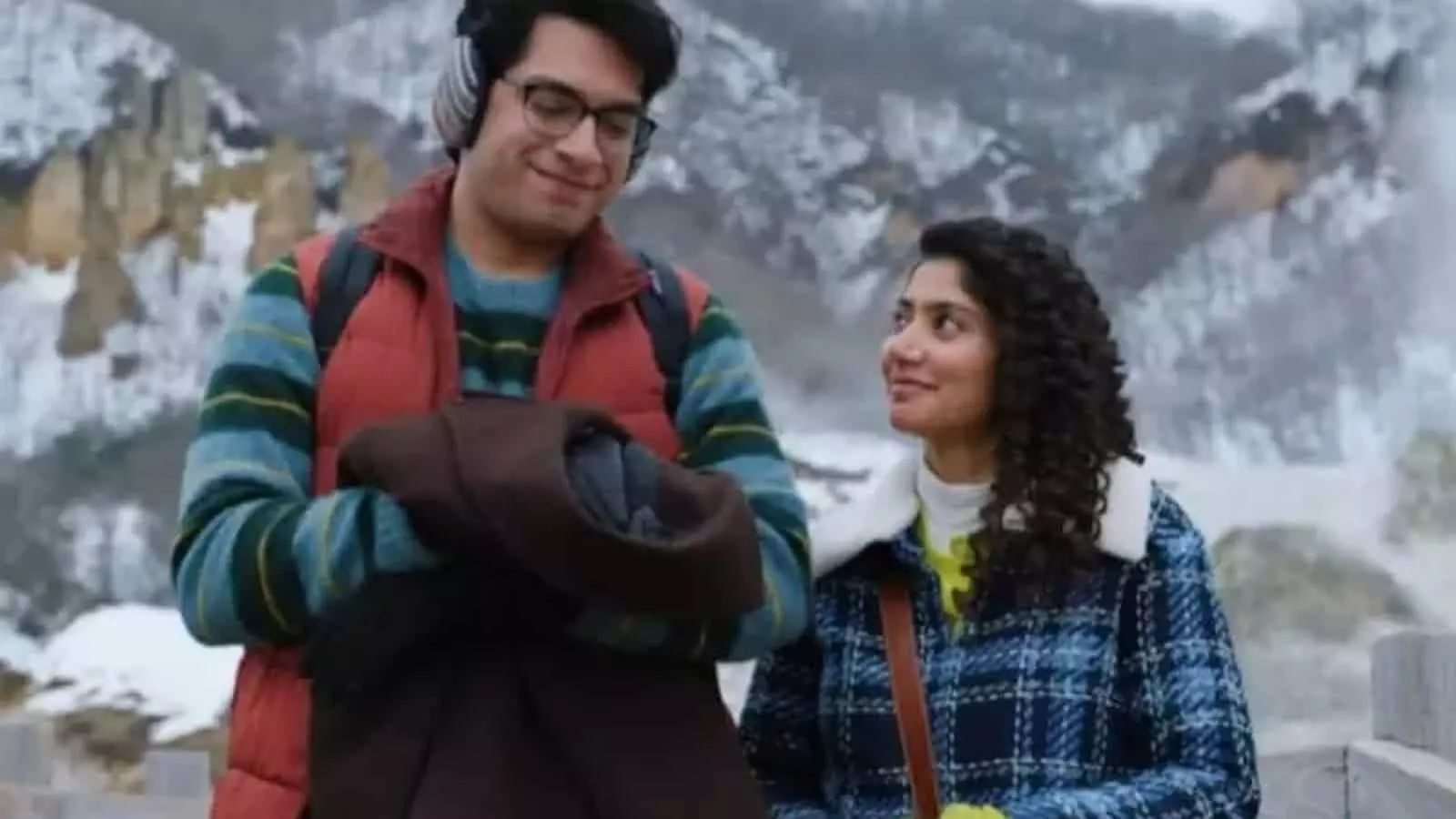 फिल्म एक दिन के दृश्य में अभिनेता जुनैद खान और अभिनेत्री साई पल्लवी बर्फीली वादियों में खड़े हैं।