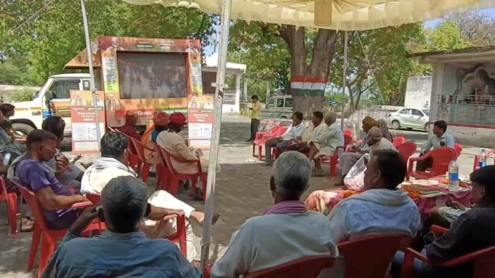 बारां के एक गांव में ग्राम रथ की एलईडी स्क्रीन पर सरकारी योजनाओं का वीडियो देखते ग्रामीण नागरिक।