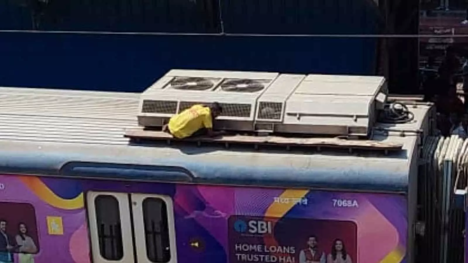 कल्याण स्टेशन पर खड़ी एसी लोकल ट्रेन की छत पर बैठा पीली शर्ट वाला युवक जिसे सुरक्षित निकाला गया। कल्याण स्टेशन पर खड़ी एसी लोकल ट्रेन की छत पर बैठा पीली शर्ट वाला युवक जिसे सुरक्षित निकाला गया।