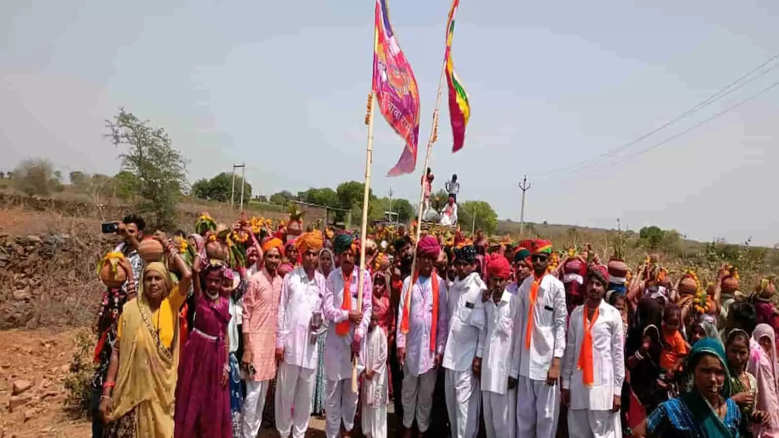 आमल्दा गांव में कलश शोभायात्रा के दौरान सिर पर कलश रखे महिलाएं और धार्मिक ध्वज लिए पुरुष श्रद्धालु।