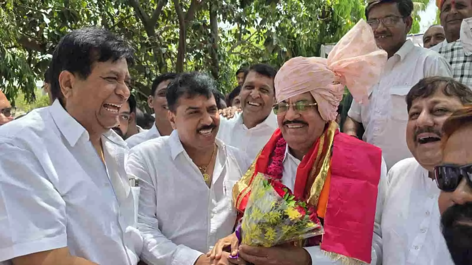 निंबाहेड़ा में जन्मदिन समारोह के दौरान साफा पहने उदय लाल आजना और अन्य कांग्रेस कार्यकर्ता फूलों के साथ।