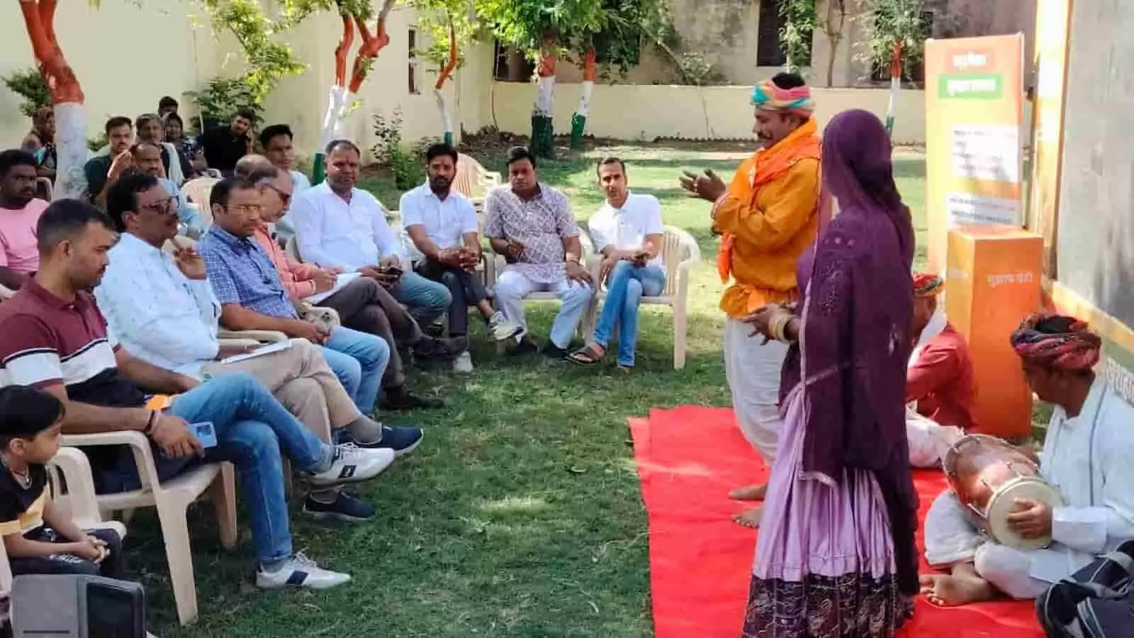 आकोला नगर पालिका में सरकारी योजनाओं के प्रचार कार्यक्रम के दौरान प्रदर्शन करते लोक कलाकार और बैठे हुए नागरिक। आकोला नगर पालिका में सरकारी योजनाओं के प्रचार कार्यक्रम के दौरान प्रदर्शन करते लोक कलाकार और बैठे हुए नागरिक।