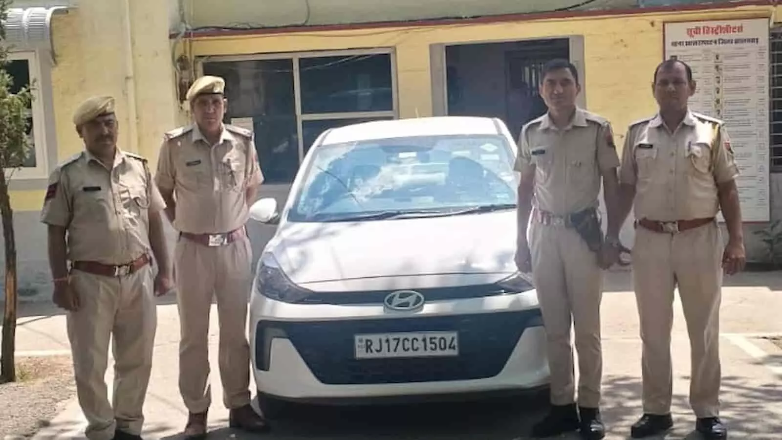 सफेद कार के साथ खड़े राजस्थान पुलिस के जवान और गिरफ्तार आरोपी मोहसिन गौरी झालरापाटन थाने के बाहर।