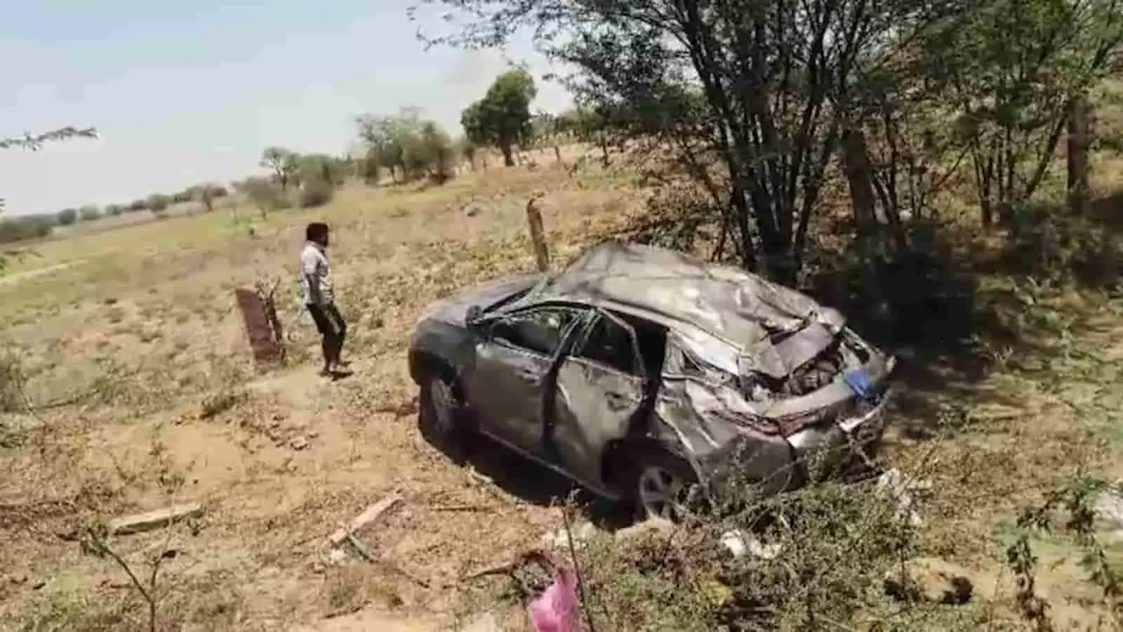 सड़क किनारे खाई में पड़ी क्षतिग्रस्त टाटा हैरियर कार और पास खड़ा एक व्यक्ति। सड़क किनारे खाई में पड़ी क्षतिग्रस्त टाटा हैरियर कार और पास खड़ा एक व्यक्ति।