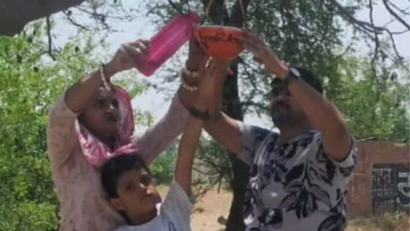 डीग में पेड़ पर पक्षियों के लिए पानी का सकोरा बांधते हुए लोग। डीग में पेड़ पर पक्षियों के लिए पानी का सकोरा बांधते हुए लोग।