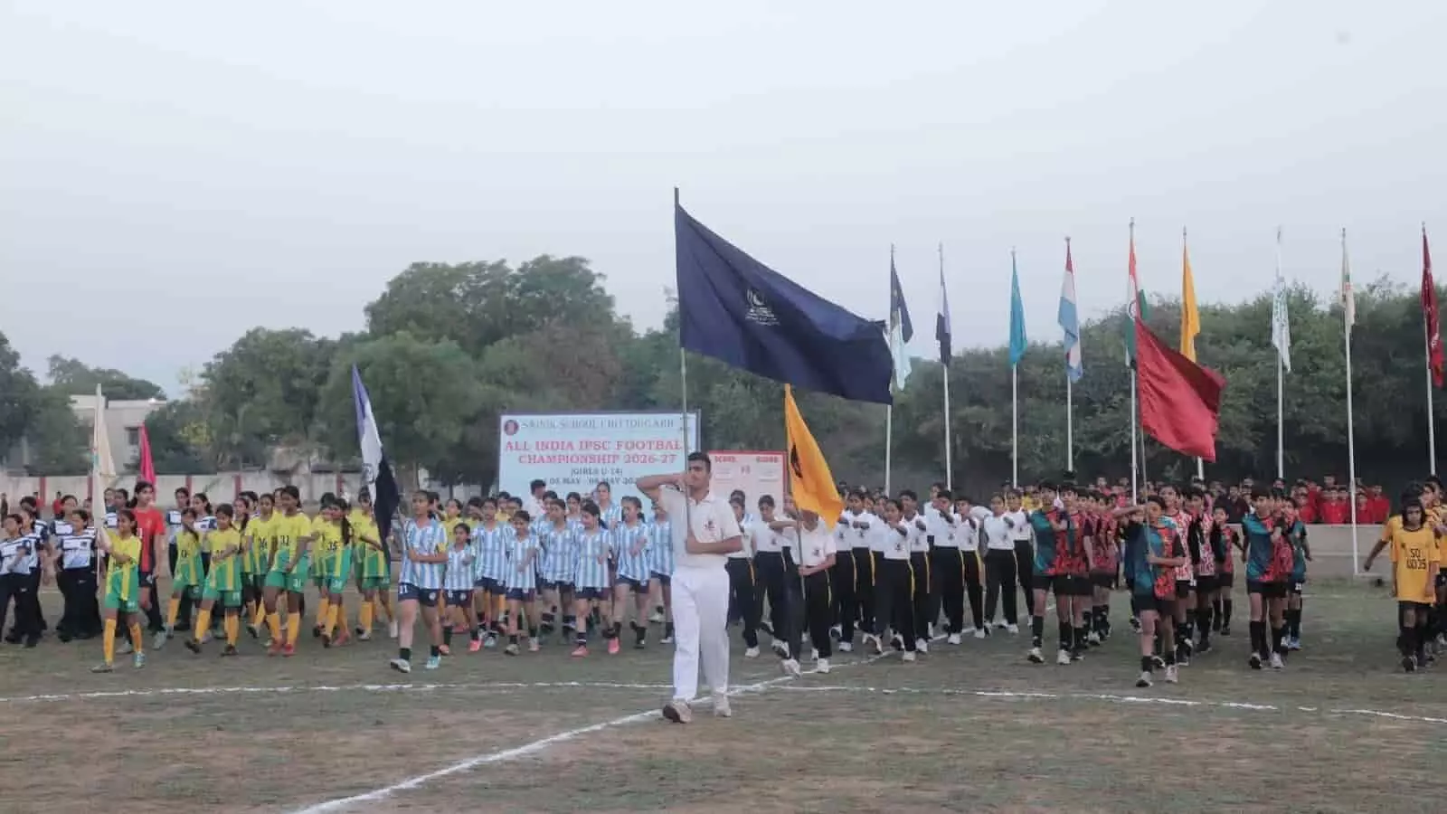 सैनिक स्कूल चित्तौड़गढ़ के खेल मैदान पर मार्च पास्ट करते फुटबॉल खिलाड़ी और छात्र।