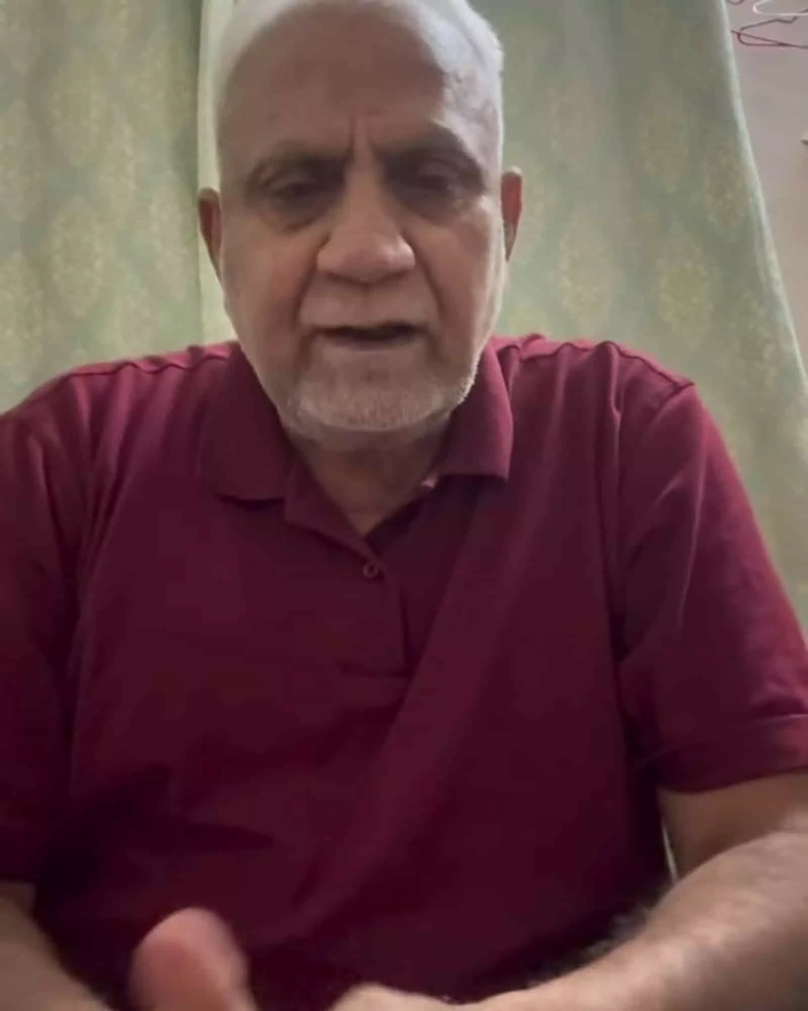 घर के अंदर साधारण पृष्ठभूमि में बैठे हुए कांग्रेस नेता अब्दुल खल्लाक की क्लोजअप तस्वीर।