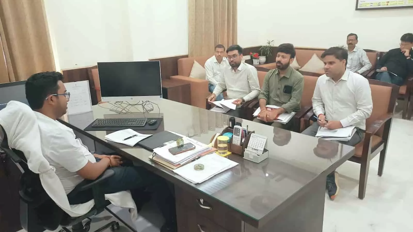 कार्यालय में मेज के चारों ओर बैठे जिला कलक्टर मयंक मनीष और अन्य अधिकारी पेयजल परियोजनाओं पर चर्चा कर रहे हैं।