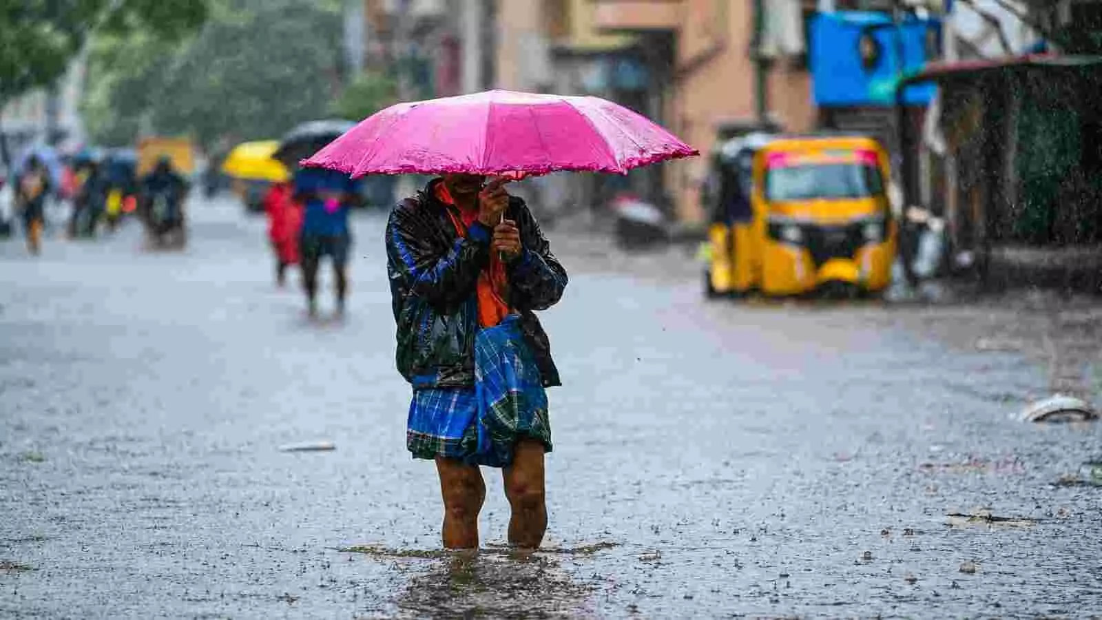 जलमग्न सड़क पर गुलाबी छाता लेकर चलता हुआ व्यक्ति चेन्नई में भारी बारिश के दौरान। जलमग्न सड़क पर गुलाबी छाता लेकर चलता हुआ व्यक्ति चेन्नई में भारी बारिश के दौरान।