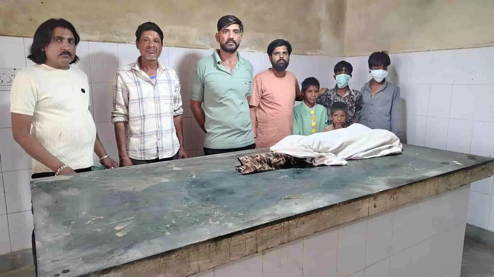 केलवाड़ा के अस्पताल में एनीकट में डूबने से मृत बालक के शव के पास खड़े ग्रामीण और परिजन।