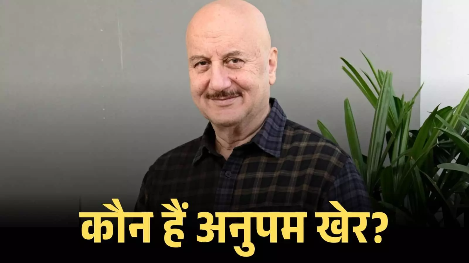 मुस्कुराते हुए बॉलीवुड अभिनेता अनुपम खेर एक धारीदार शर्ट में सादे बैकग्राउंड के सामने खड़े हैं। मुस्कुराते हुए बॉलीवुड अभिनेता अनुपम खेर एक धारीदार शर्ट में सादे बैकग्राउंड के सामने खड़े हैं।