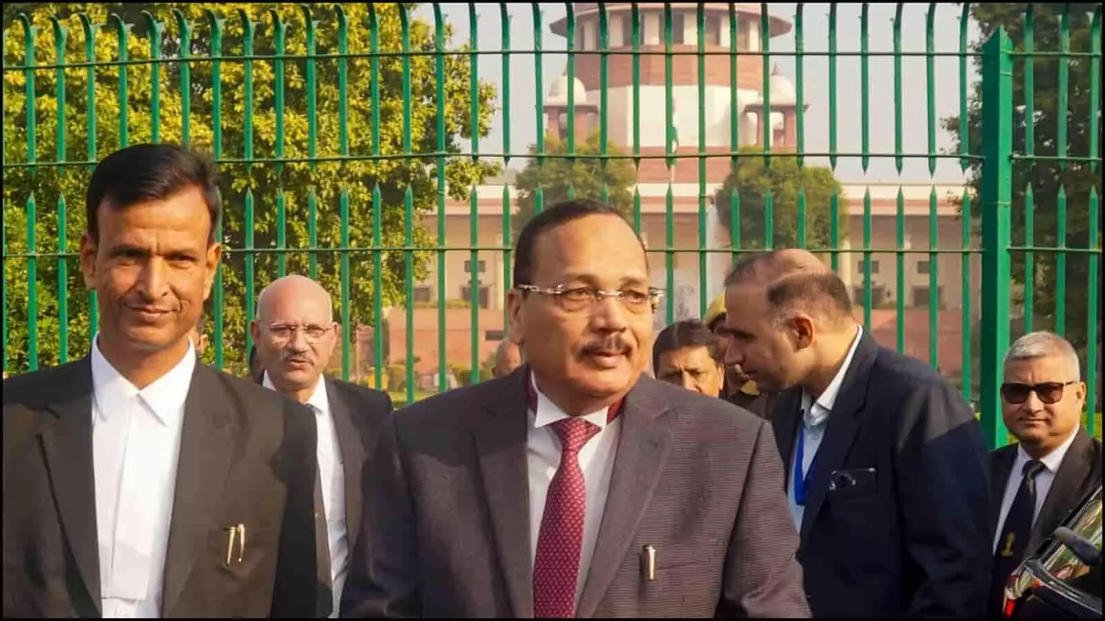 सुप्रीम कोर्ट के गेट के बाहर खड़े काले कोट पहने वकील और अधिकारी जो न्यायिक विवाद के संदर्भ में चर्चा कर रहे हैं।