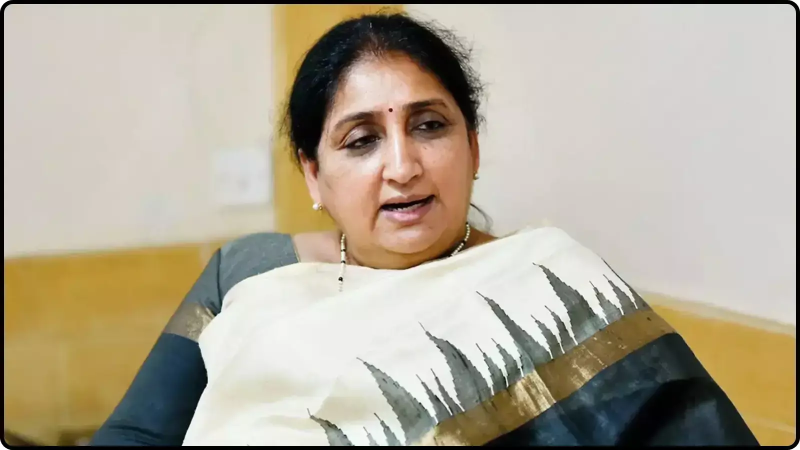 सफेद और गहरे रंग की साड़ी पहने हुए सुनेत्रा पवार एक आधिकारिक बैठक के दौरान।