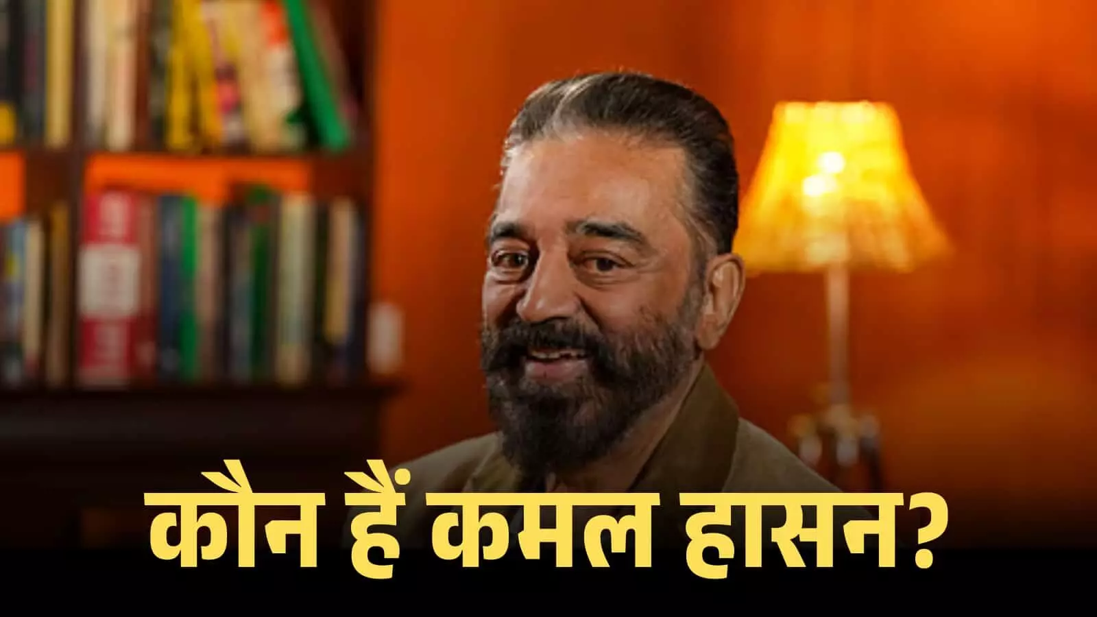 चश्मा पहने हुए मुस्कुराते अभिनेता कमल हासन एक लाइब्रेरी और लैंप के सामने इंटरव्यू दे रहे हैं। चश्मा पहने हुए मुस्कुराते अभिनेता कमल हासन एक लाइब्रेरी और लैंप के सामने इंटरव्यू दे रहे हैं।