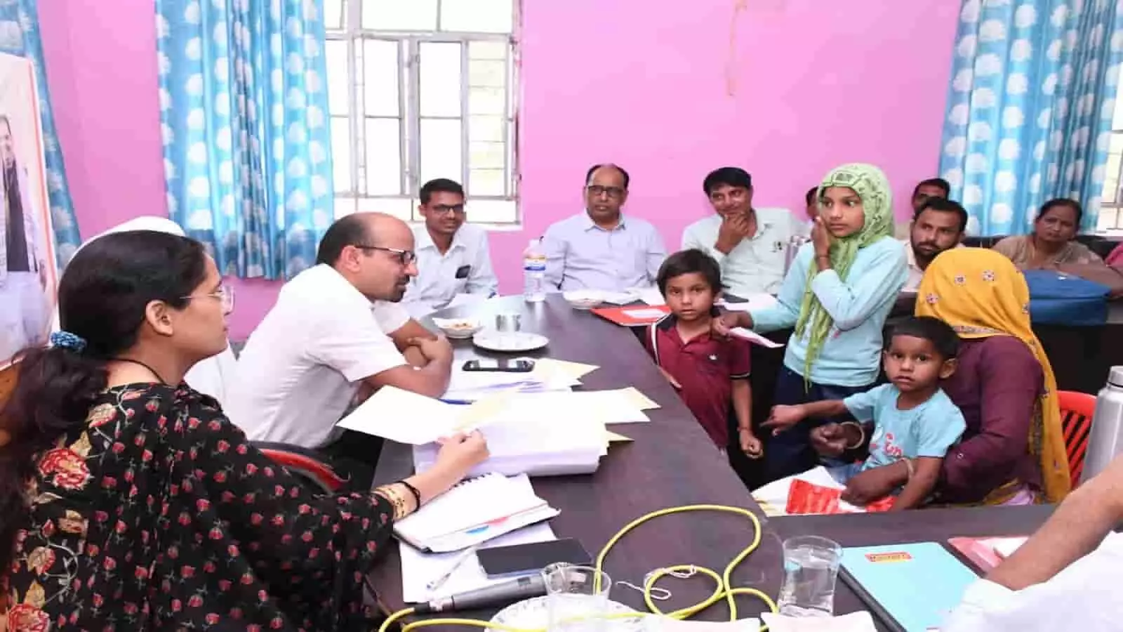 खण्डीप ग्राम पंचायत में मेज के पास बैठकर ग्रामीणों की शिकायतें सुनते हुए जिला कलक्टर काना राम और अधिकारी।