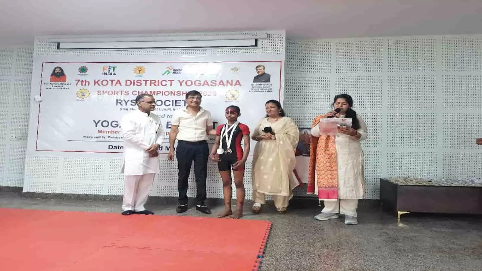 कोटा के आयुर्वेदिक कॉलेज में आयोजित योगासन प्रतियोगिता के दौरान मंच पर पुरस्कार ग्रहण करता प्रतिभागी खिलाड़ी।