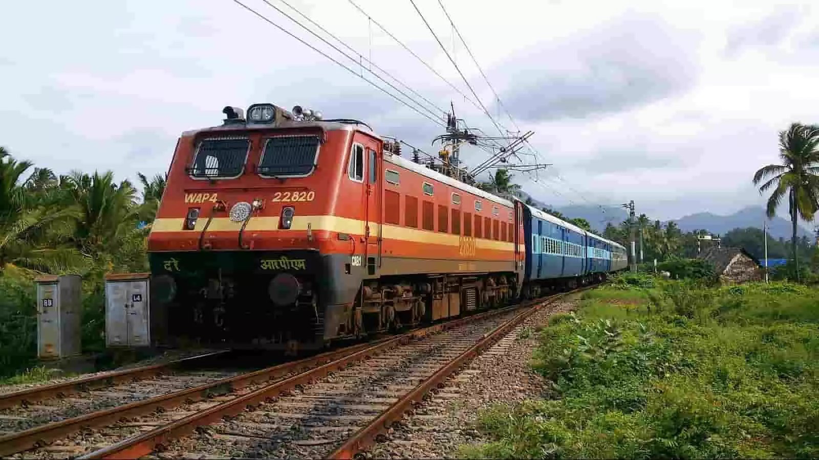 पटरी पर दौड़ता हुआ लाल डब्लूएपी4 इलेक्ट्रिक रेल इंजन और नीले रंग के कोच वाली ट्रेन। पटरी पर दौड़ता हुआ लाल डब्लूएपी4 इलेक्ट्रिक रेल इंजन और नीले रंग के कोच वाली ट्रेन।