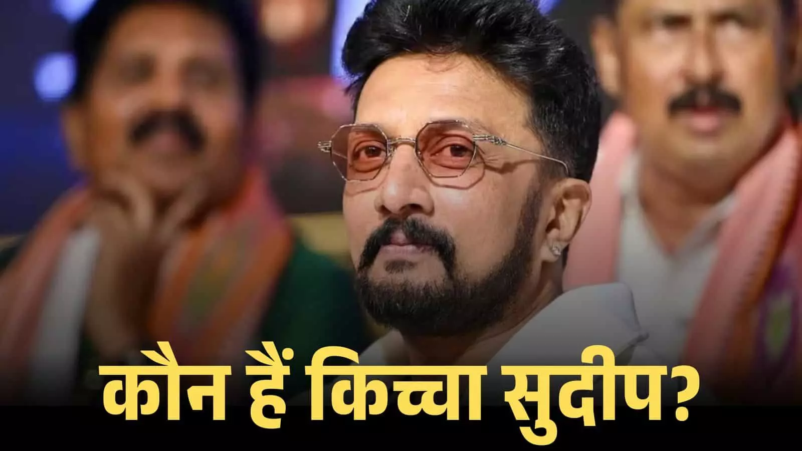 चश्मा पहने हुए अभिनेता किच्चा सुदीप एक सार्वजनिक समारोह में मंच पर बैठे हुए दिखाई दे रहे हैं। चश्मा पहने हुए अभिनेता किच्चा सुदीप एक सार्वजनिक समारोह में मंच पर बैठे हुए दिखाई दे रहे हैं।