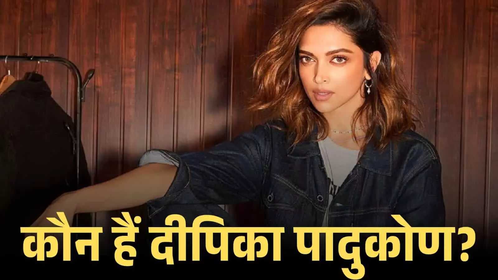 डेनिम जैकेट पहने हुए अभिनेत्री दीपिका पादुकोण एक फोटोशूट के दौरान लकड़ी की दीवार के सामने बैठी हैं।