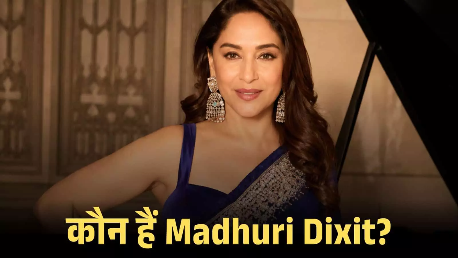 नीले रंग की साड़ी पहने हुए मुस्कुराती हुई अभिनेत्री माधुरी दीक्षित एक भव्य इनडोर बैकग्राउंड के सामने खड़ी हैं। नीले रंग की साड़ी पहने हुए मुस्कुराती हुई अभिनेत्री माधुरी दीक्षित एक भव्य इनडोर बैकग्राउंड के सामने खड़ी हैं।