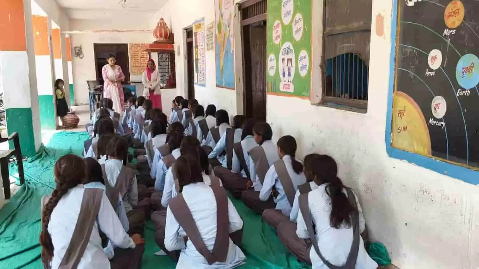 खेमपुर के स्कूल परिसर में दरी पर बैठकर जागरूकता सत्र में भाग लेतीं स्कूली छात्राएं।
