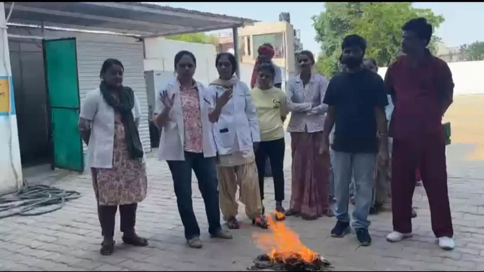 चिकित्सा संस्थान परिसर में स्वास्थ्य कर्मी आग बुझाने के उपकरणों के साथ फायर सेफ्टी मॉक ड्रिल का अभ्यास कर रहे हैं।