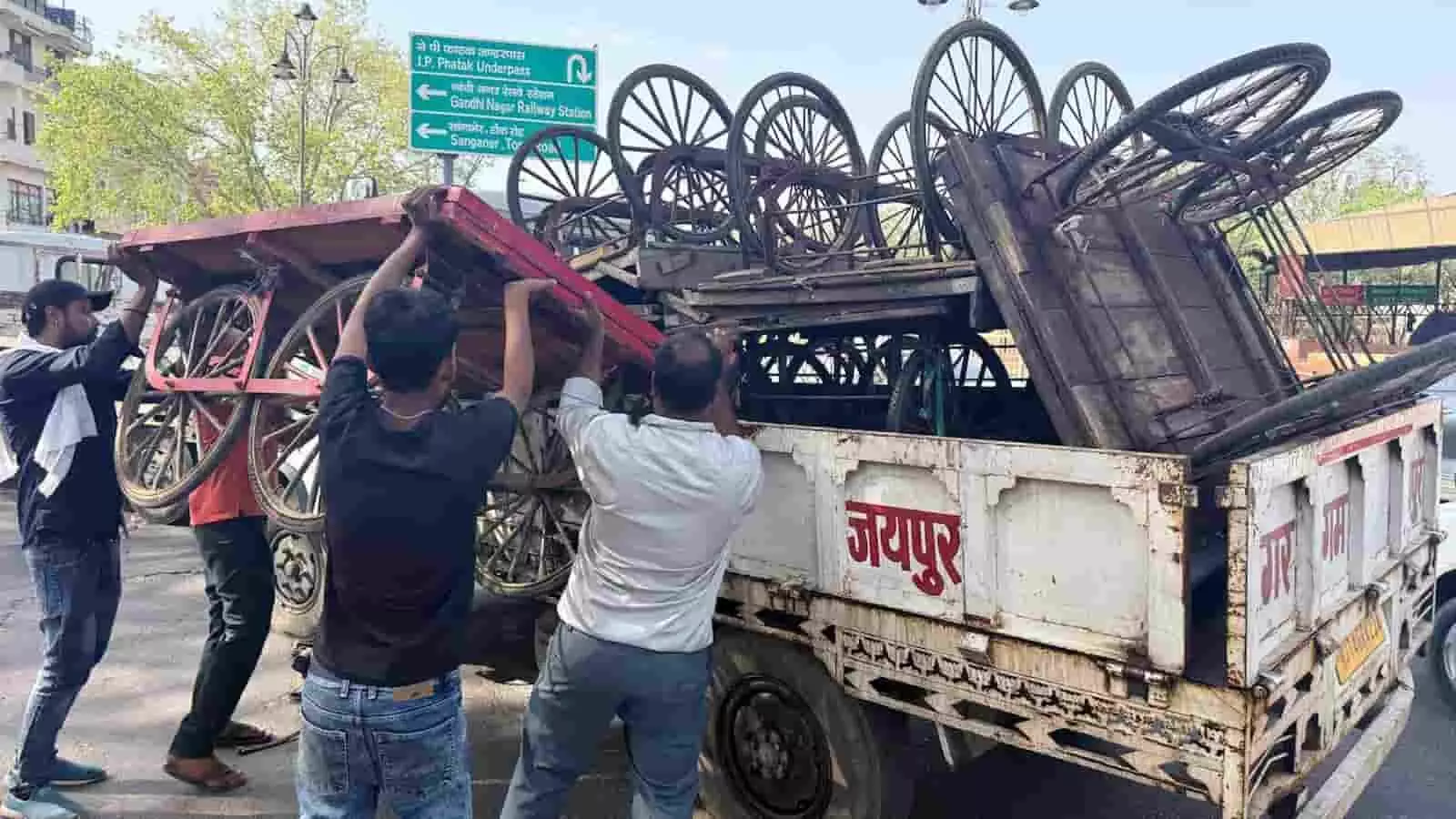 जयपुर में सड़क किनारे से जप्त किए गए ठेलों को ट्रक में रखते नगर निगम कर्मी।