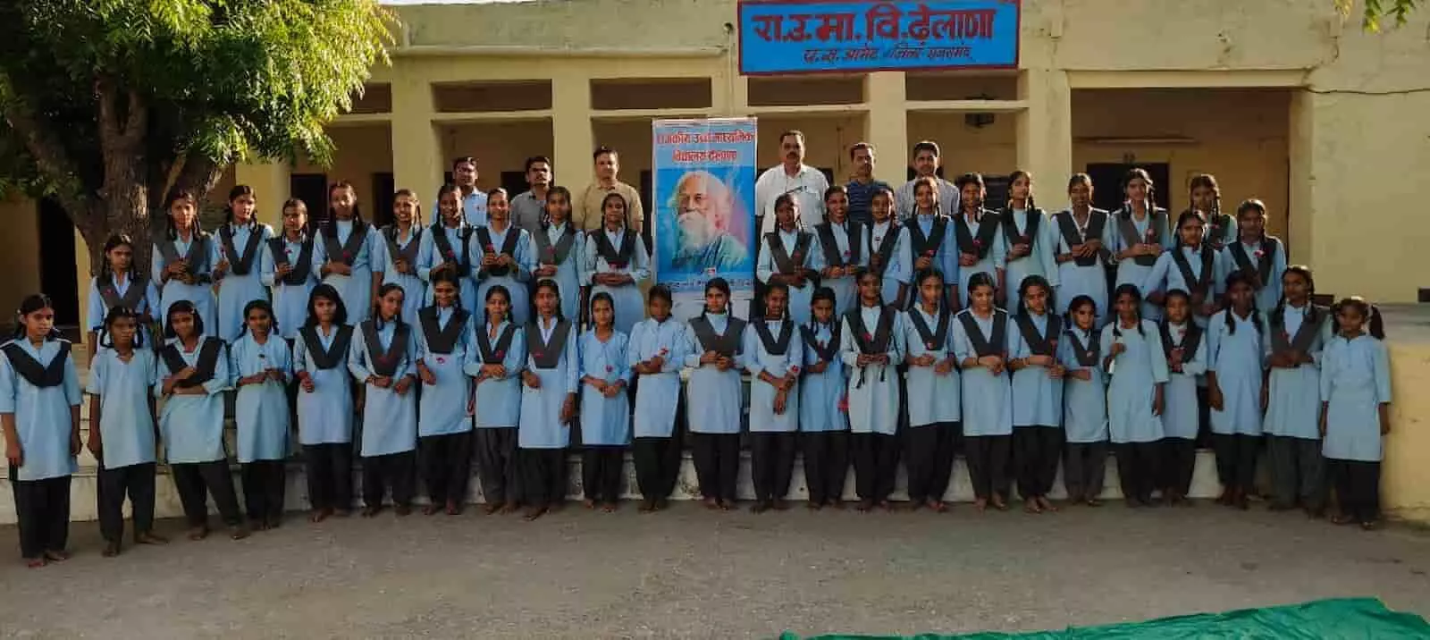 राजकीय विद्यालय भवन के बाहर कतार में खड़ी छात्राएं और पीछे खड़े शिक्षक संगठन विस्तार के अवसर पर।