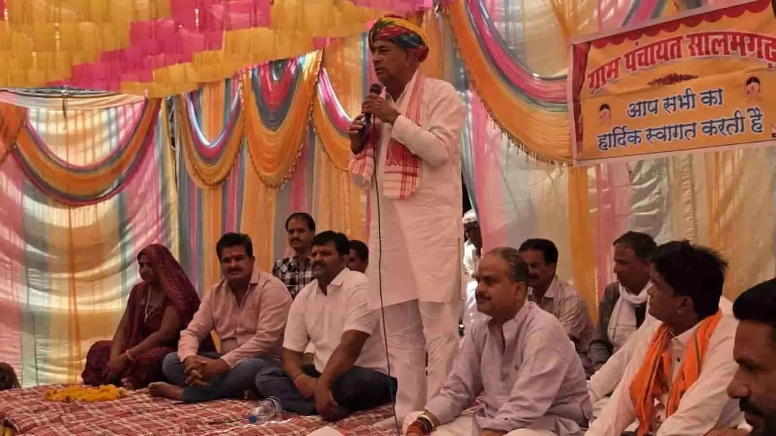 मंच पर माइक थामे भाषण देते मंत्री हेमंत मीणा और सामने बैठे स्थानीय ग्रामीण जनप्रतिनिधि। मंच पर माइक थामे भाषण देते मंत्री हेमंत मीणा और सामने बैठे स्थानीय ग्रामीण जनप्रतिनिधि।