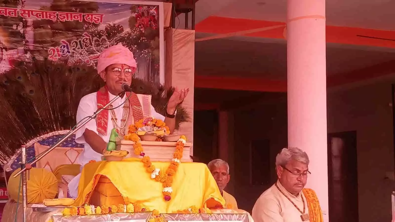 व्यास पीठ पर बैठकर माइक के सामने प्रवचन देते पंडित मुकुट बिहारी शास्त्री बौराज श्रीमद्भागवत कथा में। व्यास पीठ पर बैठकर माइक के सामने प्रवचन देते पंडित मुकुट बिहारी शास्त्री बौराज श्रीमद्भागवत कथा में।