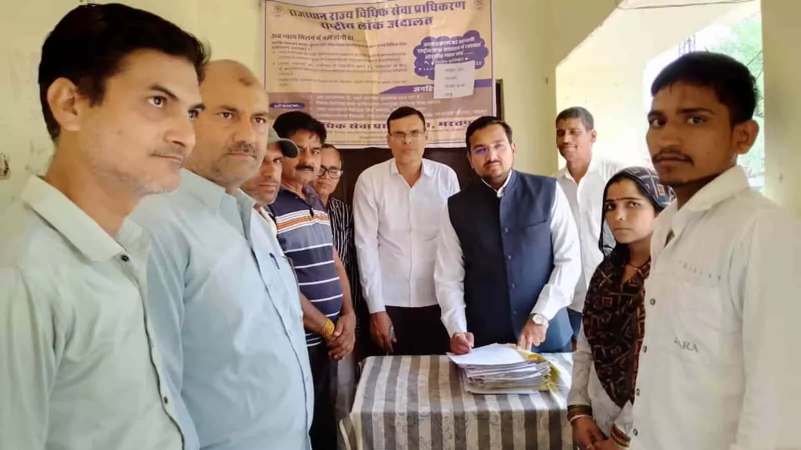 भुसावर न्यायालय में लोक अदालत के दौरान बैनर के सामने खड़े न्यायिक अधिकारी और पक्षकार। भुसावर न्यायालय में लोक अदालत के दौरान बैनर के सामने खड़े न्यायिक अधिकारी और पक्षकार।