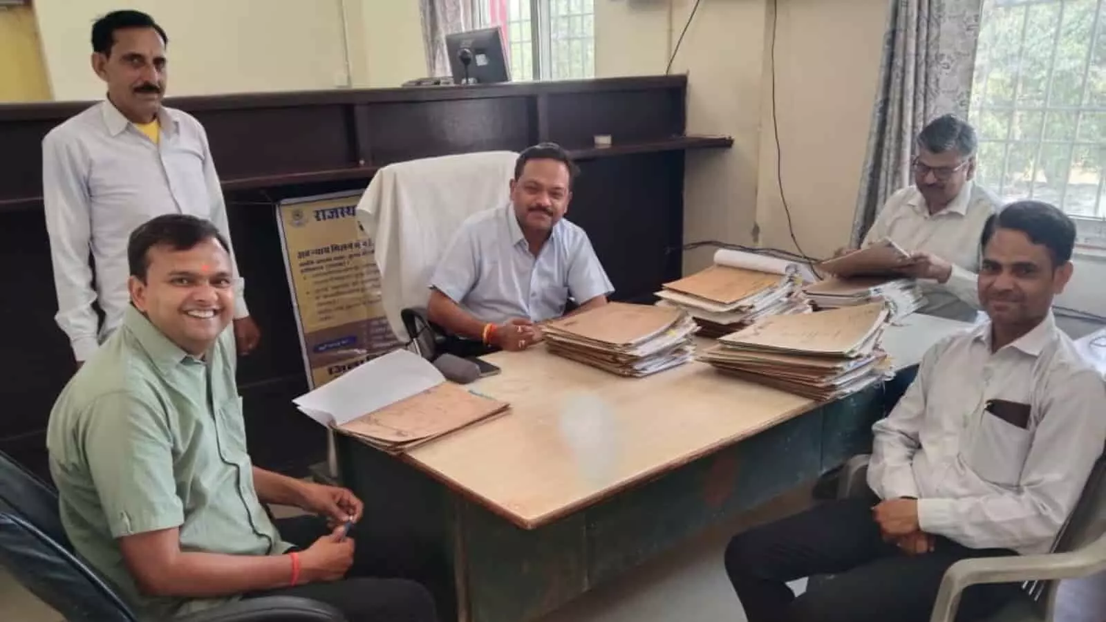 वइर न्यायालय में बेंच के समक्ष फाइलों के साथ बैठे न्यायिक अधिकारी और अधिवक्ता लोक अदालत के दौरान। वइर न्यायालय में बेंच के समक्ष फाइलों के साथ बैठे न्यायिक अधिकारी और अधिवक्ता लोक अदालत के दौरान।