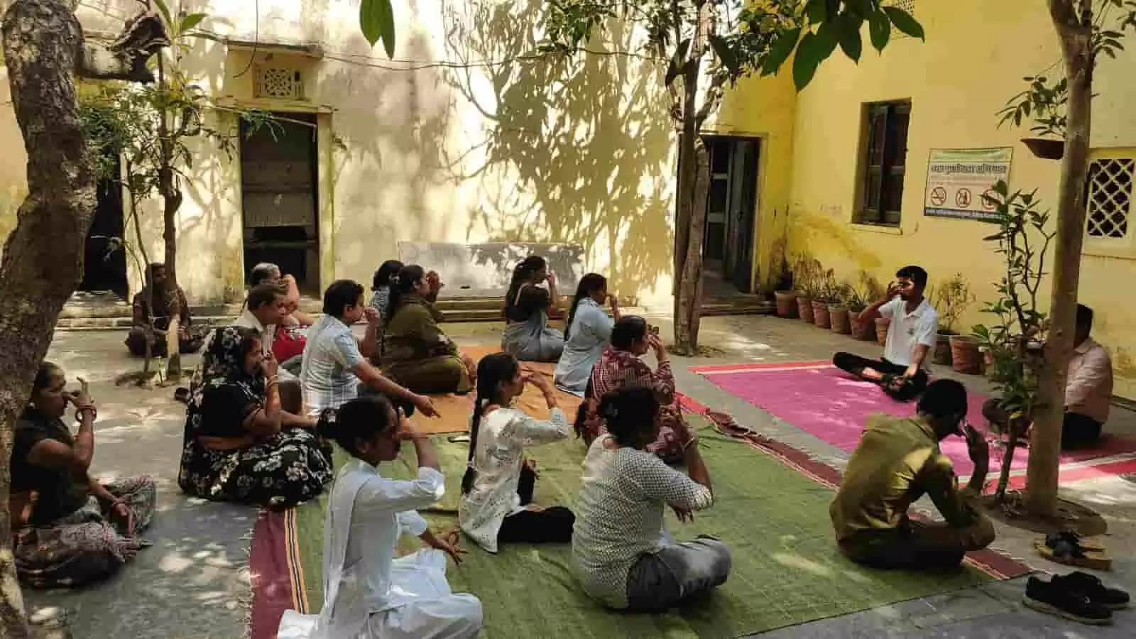 राजकीय जिला आयुर्वेद चिकित्सालय में योगाभ्यास और प्राणायाम करते हुए प्रतिभागी और प्रशिक्षक।