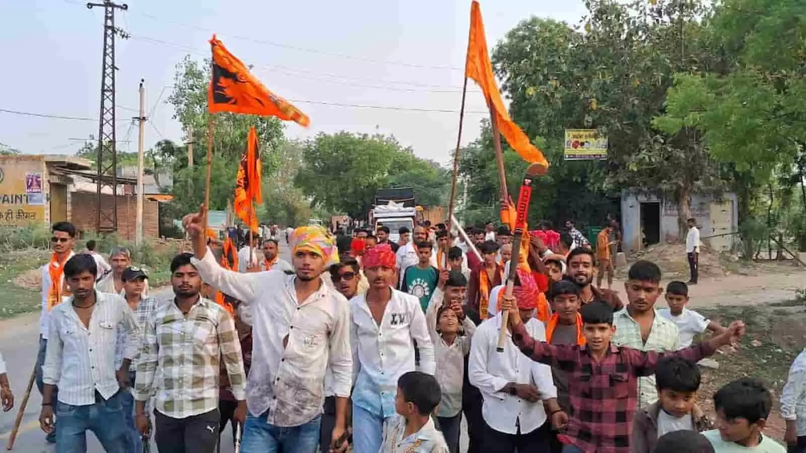 डीग के अऊ गांव की सड़क पर केसरिया झंडे लेकर शोभायात्रा निकालते हुए स्थानीय ग्रामीण और बच्चे। डीग के अऊ गांव की सड़क पर केसरिया झंडे लेकर शोभायात्रा निकालते हुए स्थानीय ग्रामीण और बच्चे।