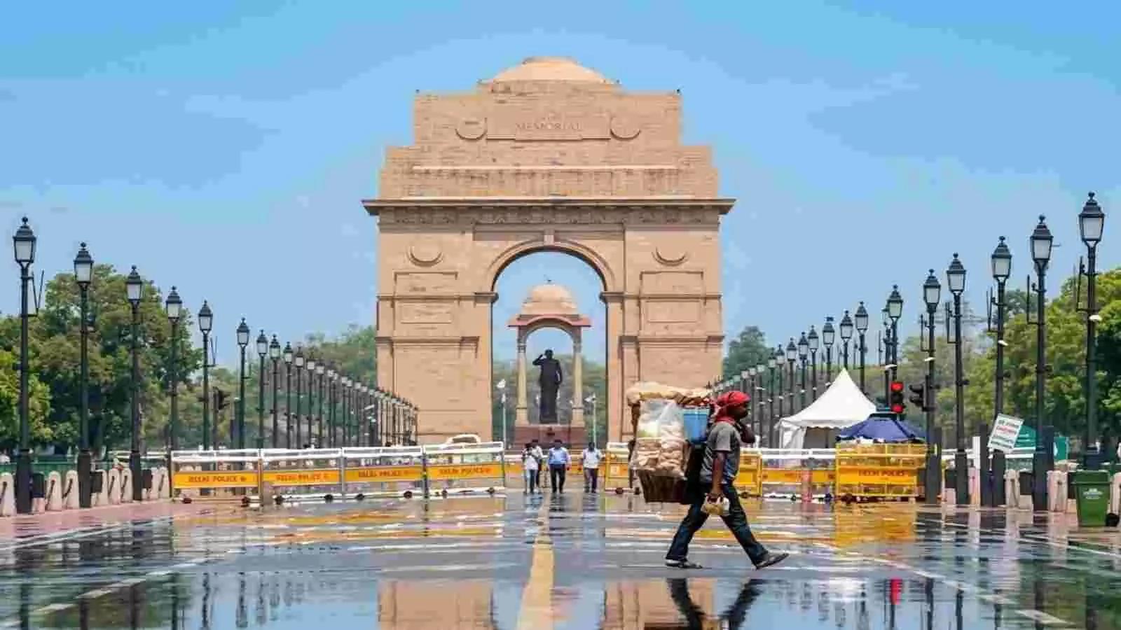 नई दिल्ली में इंडिया गेट के सामने गीली सड़क पर पैदल चलता व्यक्ति और मौसम का दृश्य। नई दिल्ली में इंडिया गेट के सामने गीली सड़क पर पैदल चलता व्यक्ति और मौसम का दृश्य।