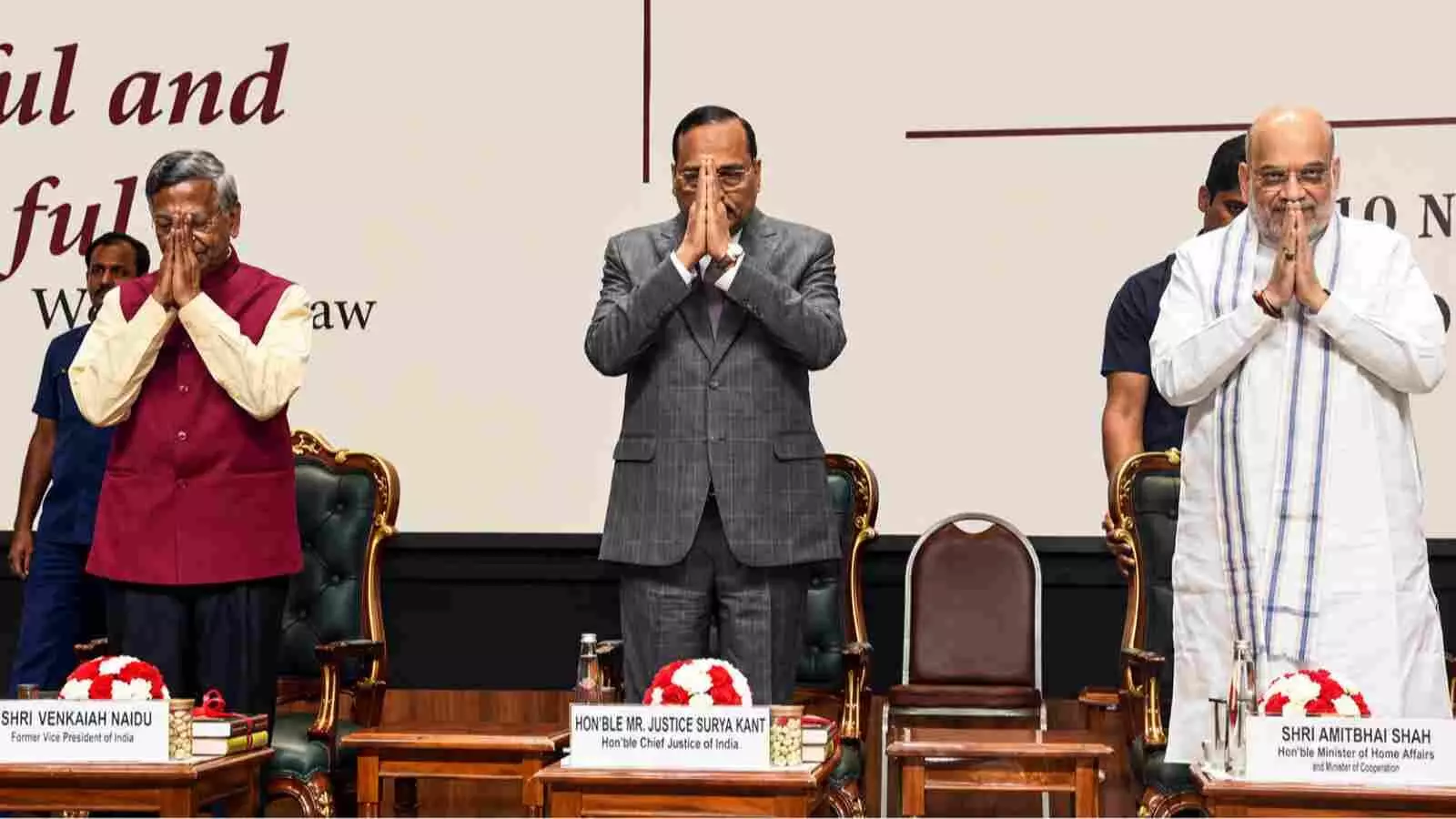 समारोह के मंच पर खड़े होकर हाथ जोड़कर नमस्ते करते हुए तीन भारतीय विशिष्ट अतिथि।