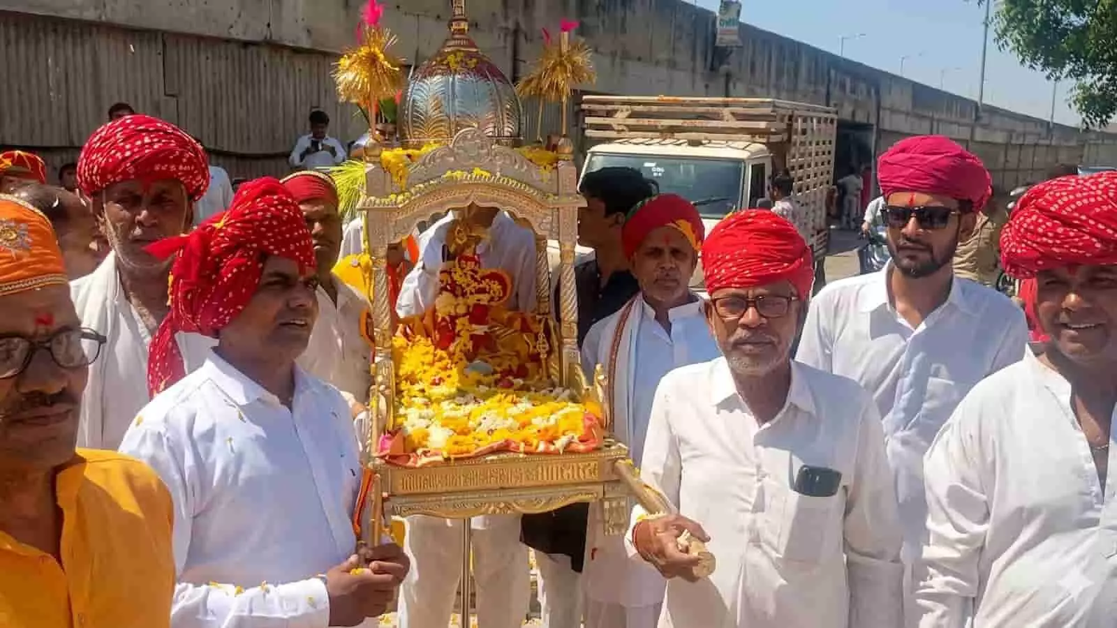 सनवाड़ में चारभुजा मंदिर प्राण-प्रतिष्ठा महोत्सव की कलश यात्रा में पालकी ले जाते श्रद्धालु।